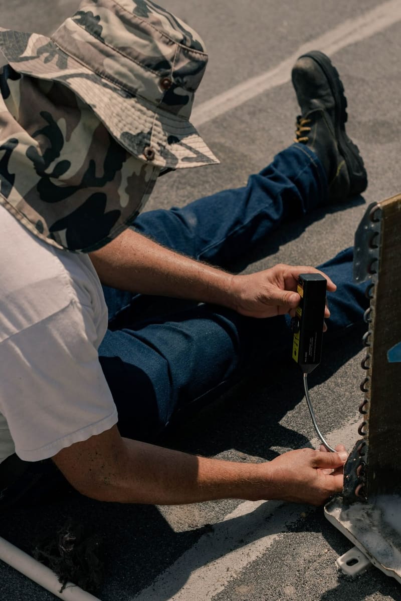 Air conditioning engineer checking refrigerant pressure with a gauge during a service