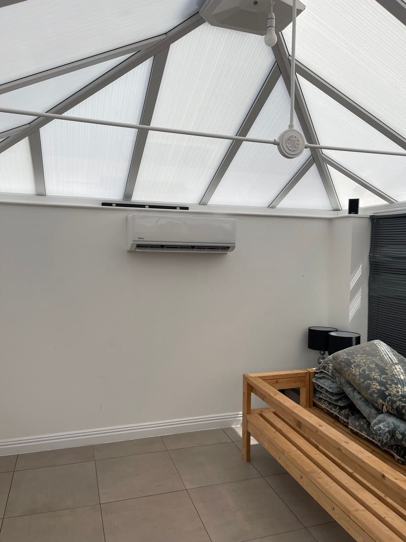 Air conditioning unit installed in a glazed conservatory with a lantern roof
