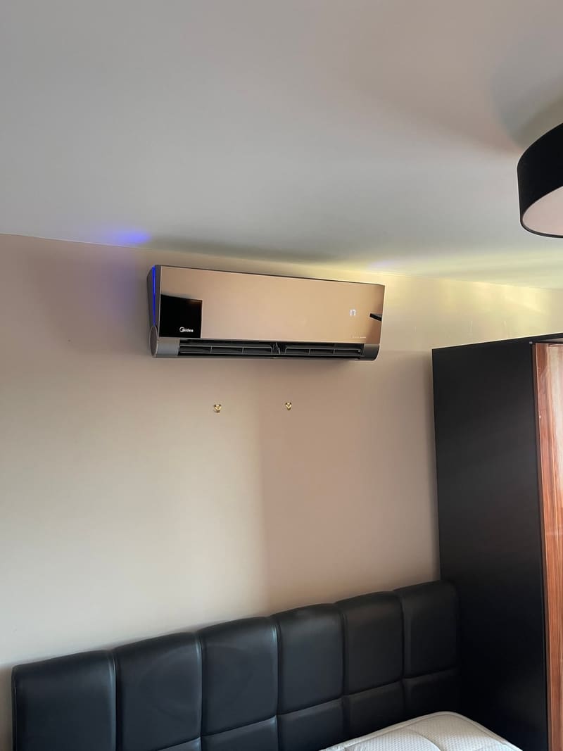 Designer-finish wall-mounted air conditioner in a bedroom