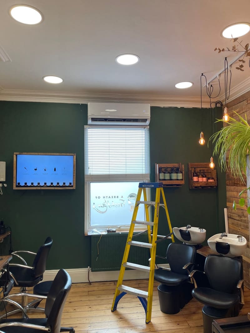 Wall-mounted air conditioning unit installed in a hair salon