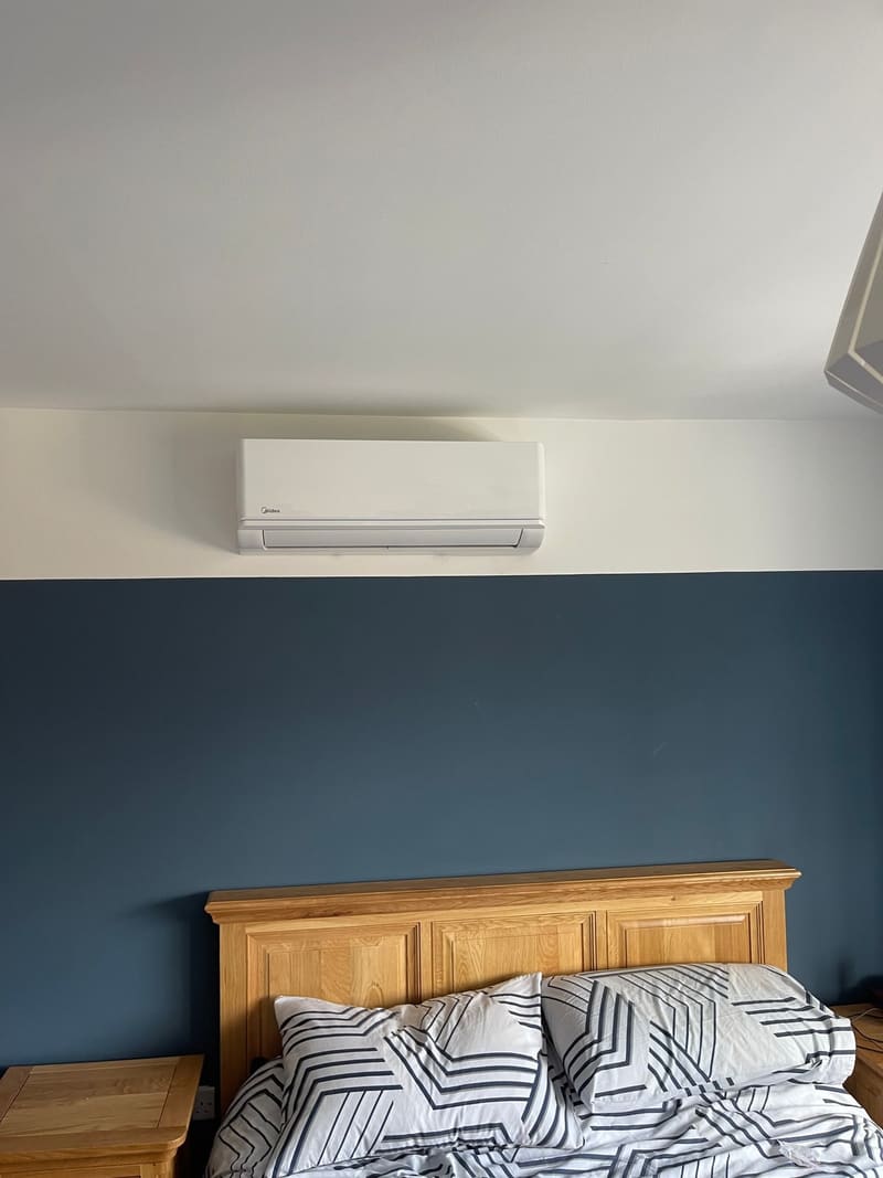 Slim wall-mounted home air conditioner on a dark grey feature wall