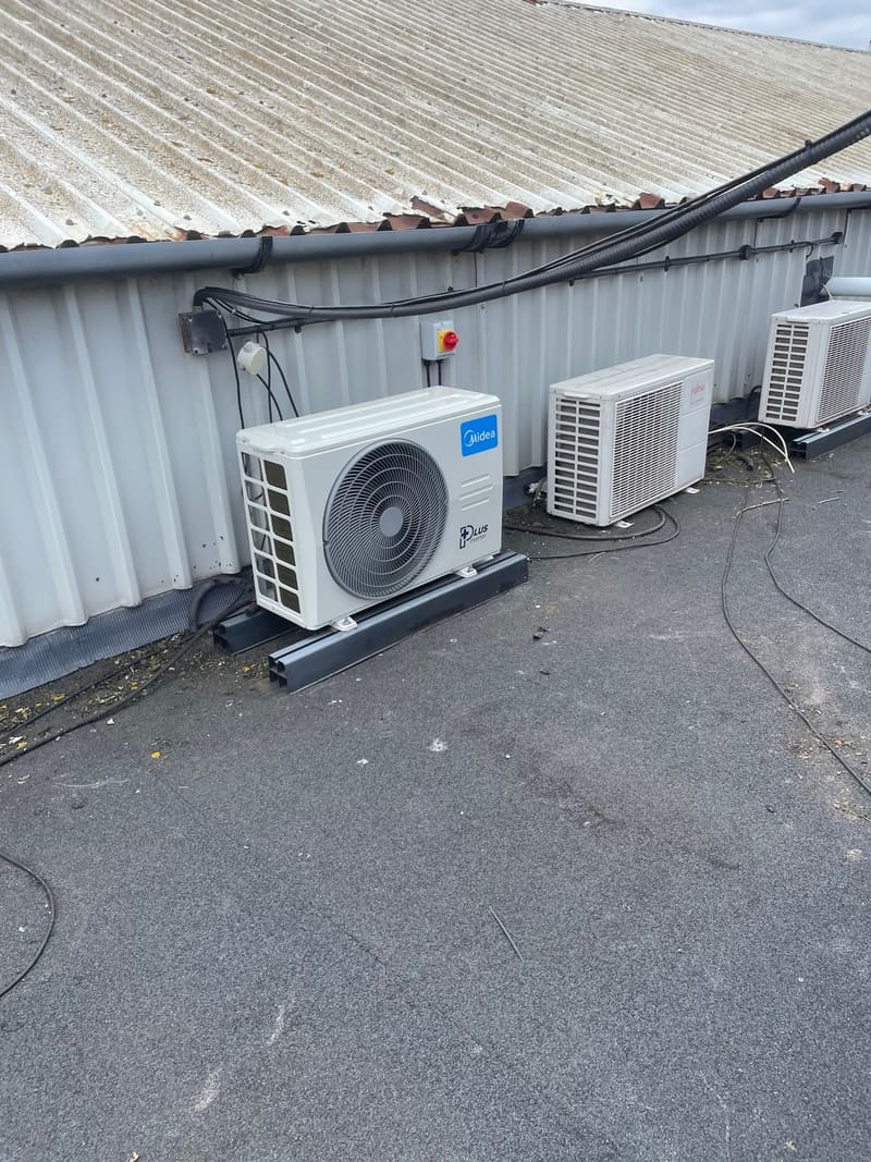 Row of commercial air conditioning condensers outside an industrial unit